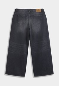 Σκούρο τζιν παντελόνι με φαρδιά γραμμή, με ξεθωριασμένο πλύσιμο, δύο πίσω τσέπες και ταμπέλα από ταμπά δέρμα με μεταλλικές λεπτομέρειες.