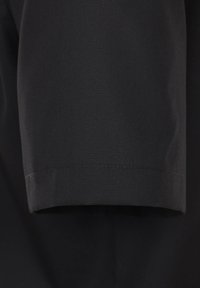 Schwarzer Stoff mit glatter Textur, ausgestattet mit einem gefalteten Ärmelumschlag und präziser Naht entlang der Kante. Keine sichtbaren Muster oder Akzente.