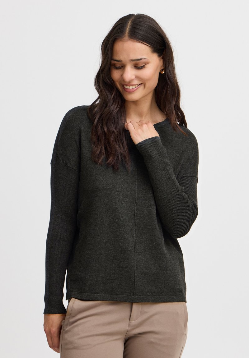 Pull en maille vert foncé à la coupe décontractée, à manches longues et avec des accents côtelés aux poignets. Texture lisse, design simple et encolure ras du cou.