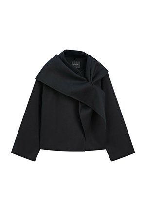 Veste noire à manches longues avec un large revers drapé sur le devant, fabriquée dans un tissu épais avec une coupe structurée et carrée.