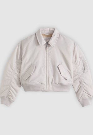 Veste bomber courte beige clair avec fermeture éclair frontale, poches à rabat boutonnées, poche zippée sur la manche, et poignets et ourlet côtelés.