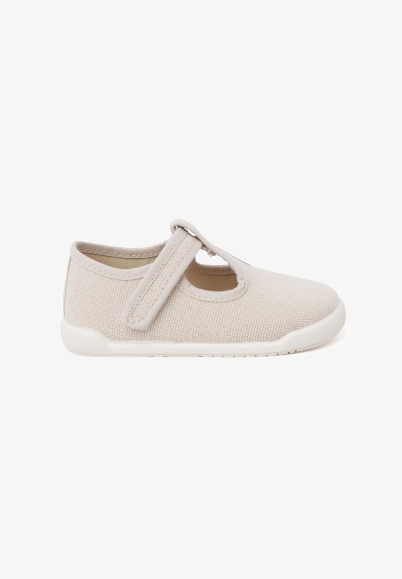 Chaussure Mary Jane en toile beige avec une sangle Velcro, bout arrondi et dessus texturé. Semelle en caoutchouc pour une meilleure adhérence et confort.