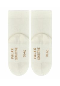 Beige, kurz geschnittene Socken mit verstärkter Ferse und Zehen. Hergestellt aus einem weichen, glatten Stoff, auf dem "Falke Sensitive" in Gold gedruckt ist.