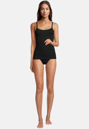 Camicetta nera con spalline sottili, realizzata in un tessuto morbido e elasticizzato. Ha un design aderente e cade fino all'altezza dell'hip, indossata con culotte coordinate.