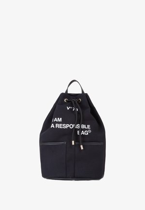 Mochila de lona negra con cordón, con dos bolsillos frontales, que presenta texto blanco: "SOY UNA MOCHILA RESPONSABLE." Acentos en tono dorado.
