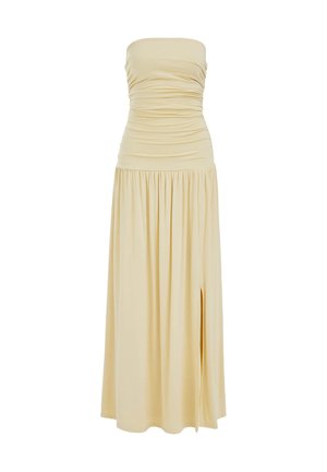 Smėlio spalvos ilga suknelė be petnešėlių, su raukšlėtu liemeniu, sijonas surinktas ir aukštas šonas plyšys dešinėje, parodyta ant balto fono.