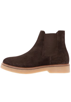 Bottines en suede marron avec des panneaux latéraux en élasthanne, bout rond et semelle en caoutchouc léger ; présente des coutures contrastantes le long de la semelle.