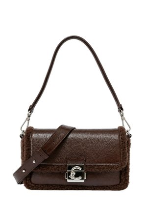 Borsa a mano in pelle marrone scuro e shearling con chiusura twist-lock argento e due spallacci regolabili su sfondo bianco.