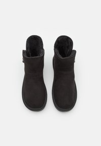 Stivaletti neri in suede con una morbida fodera interna e suole testurizzate, caratterizzati da un gambo liscio e una cerniera laterale decorativa.