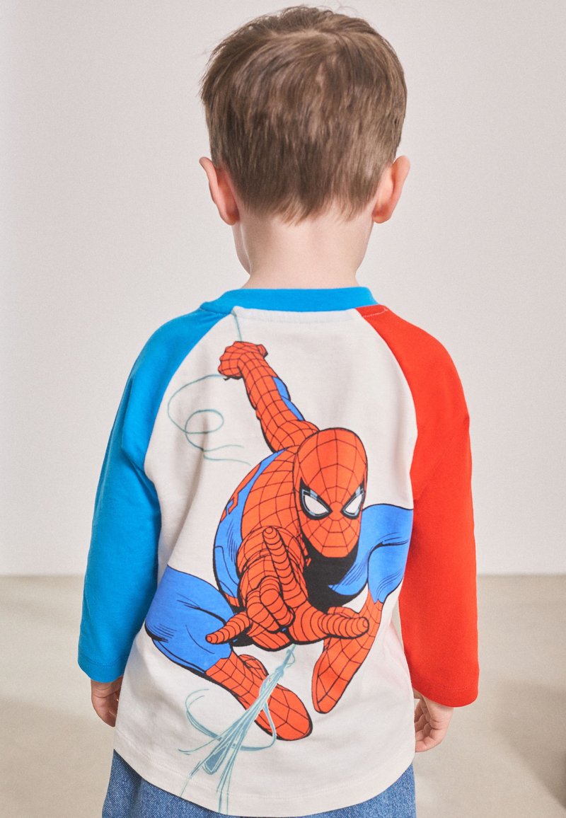 T-shirt blanc avec des manches raglan bleues et rouges. Présente un grand graphisme de Spider-Man au dos, mettant en valeur des couleurs vives et des détails.
