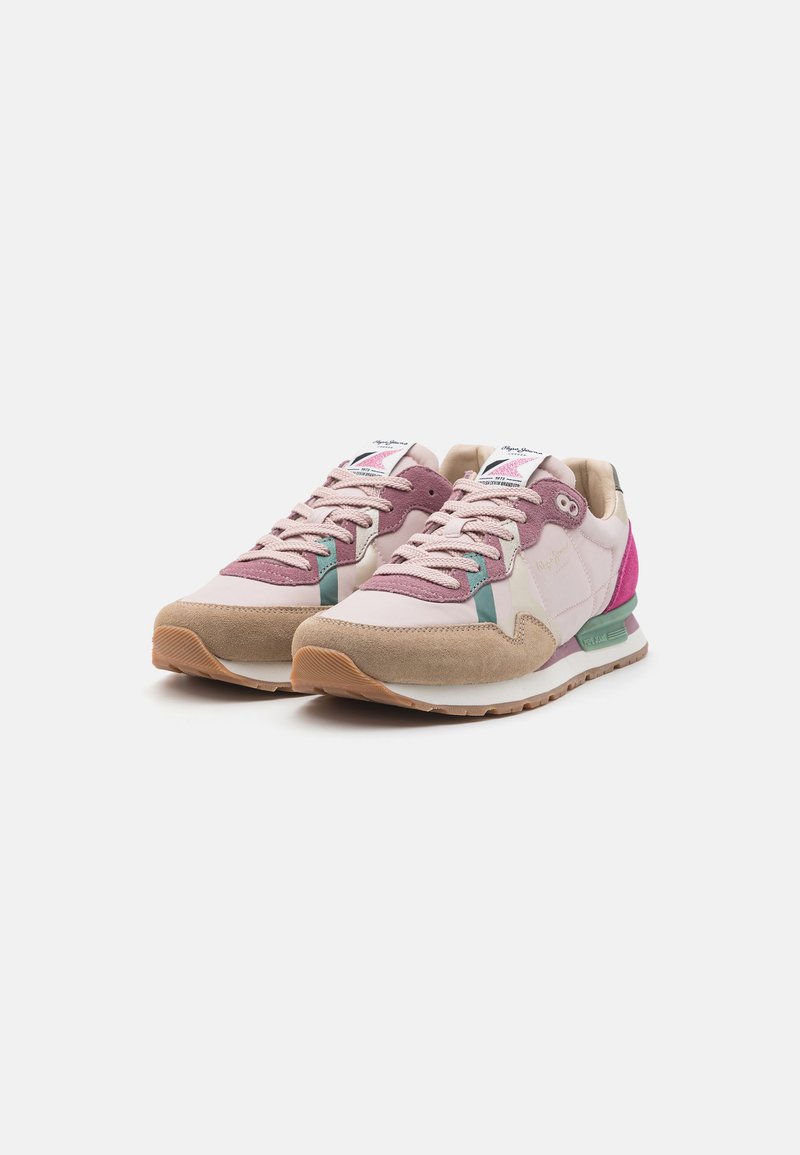 Rosa und beige Sneakers aus einer Mischung von Wildleder und Mesh-Materialien. Verfügen über einen grünen Akzent und eine strukturierte Gummi-Sohle.