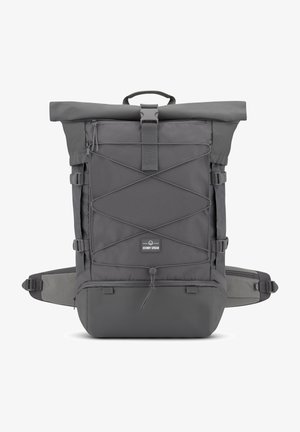 Zaino grigio a chiusura superiore realizzato in tessuto resistente, con un esterno in rete e cinghie incrociate, tasche laterali e spallacci imbottiti.