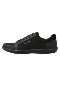 Schwarze, niedrige Calvin Klein Sneaker mit geschnürtem Design und strukturierten Paneelen, seitlichem Logo und Gummisohle.