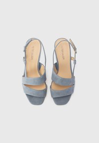 Blue suede slingback sandals featuring wide straps, a square toe, and a low block heel. Adjustable ankle strap included.