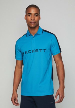 Polo shirt in bright blue with navy accents, featuring a collar, short sleeves, and "HACKETT" logo printed across the chest.
