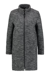 Cappotto intrecciato in bianco e nero con colletto alto, zip anteriore e maniche lunghe. Motivo testurizzato su tutta la stoffa.