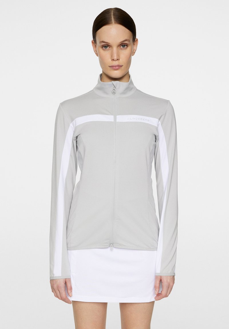 Hellgraue Zip-Jacke mit weißen Seitenpaneelen, aus glattem Stoff; verfügt über einen Stehkragen und Branding auf der Brust.