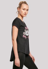 Svart T-skjorte med korte ermer og buet søm. Den har et lekent kattegraphikk i hvitt og rosa. Myk stoff, avslappet design, egnet for uformell bruk.