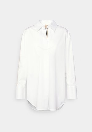 White long-sleeve button-up shirt with a pointed collar and brown and black trim along the inside of the placket and sleeves.