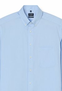 Camicia azzurra chiara con bottoni realizzata in tessuto intrecciato, dotata di colletto, tasca frontale e una singola tasca sul petto con un discreto dettaglio del logo.