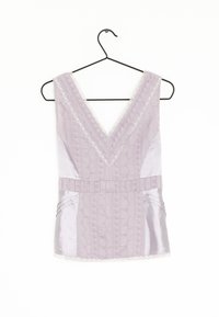 Lavender sleeveless top with a V-neck, featuring textured fabric, lace trim, and pleated accents on the waist and sides. Hangs on a black hook.