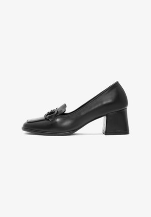 Zapato de tacón alto de cuero negro con punta redondeada, una correa decorativa con detalle de hebilla y un tacón grueso. Textura suave.