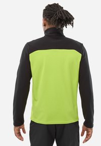 Black and neon green fleece jacket with a textured surface, featuring long sleeves and a high collar design.