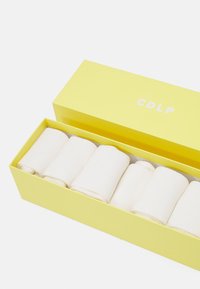 Ensemble de six rouleaux en coton blanc emballés dans une boîte jaune clair avec "CDLP" imprimé en blanc sur le couvercle. Texture lisse, forme cylindrique.