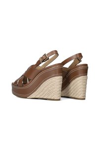 Bruine leren wedge sandalen met een gevlochten juten hak, open teen en dubbele banden. Kenmerkend zijn een gouden gesp accent en witte stikdetails.