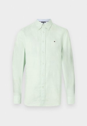 Chemise boutonnée à manches longues vert clair en tissu texturé, dotée d'un col classique, de boutons sur le devant, et d'un petit logo sur la poitrine.