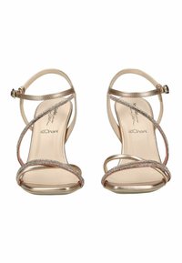 Sandali da donna metallizzati dorati con sottili cinturini alla caviglia, punta aperta e soletta in memory foam, fotografati frontalmente su sfondo bianco.
