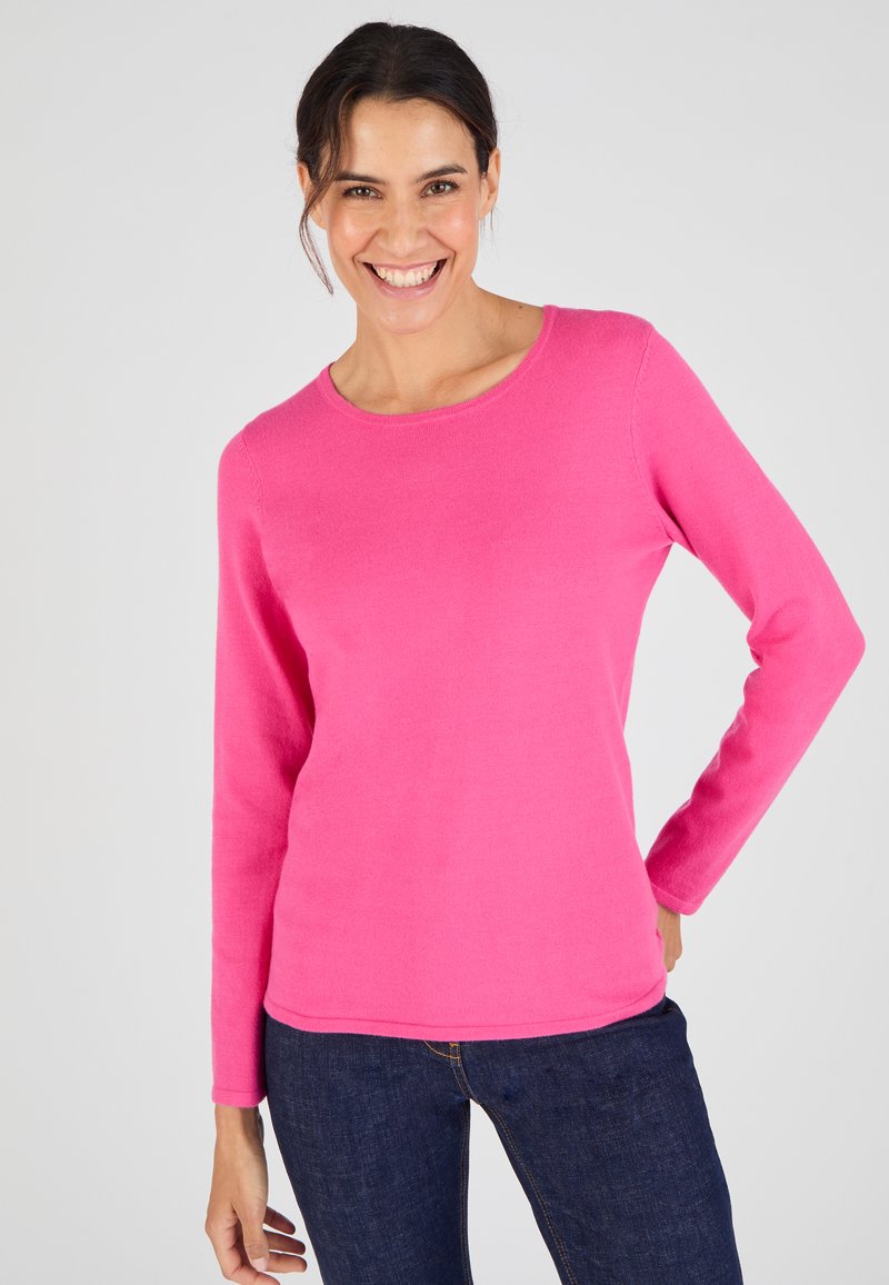 Roze lange mouwen trui gemaakt van zacht materiaal met een ronde hals en een gladde textuur, gedragen met donkerblauwe denim jeans.