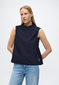 Camicia senza maniche blu navy con colletto classico. Realizzata in tessuto liscio, presenta un taglio dritto e leggere aperture laterali.