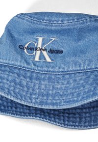 Lysblå denim bucket hat med opkrøllet skygge, prydet med broderede "CK" og "Calvin Klein Jeans" logoer i kontrasterende hvid og marineblå.