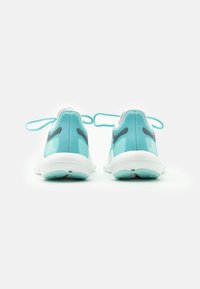 Scarpe da corsa turchesi con suole bianche, con una texture liscia, forma arrotondata e dettagli grigi sul tallone e sui lati.