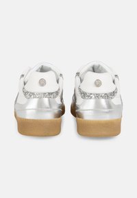 White leather sneakers with silver metallic accents, glitter trim, and a brown rubber sole. Features a circular logo on the heel.