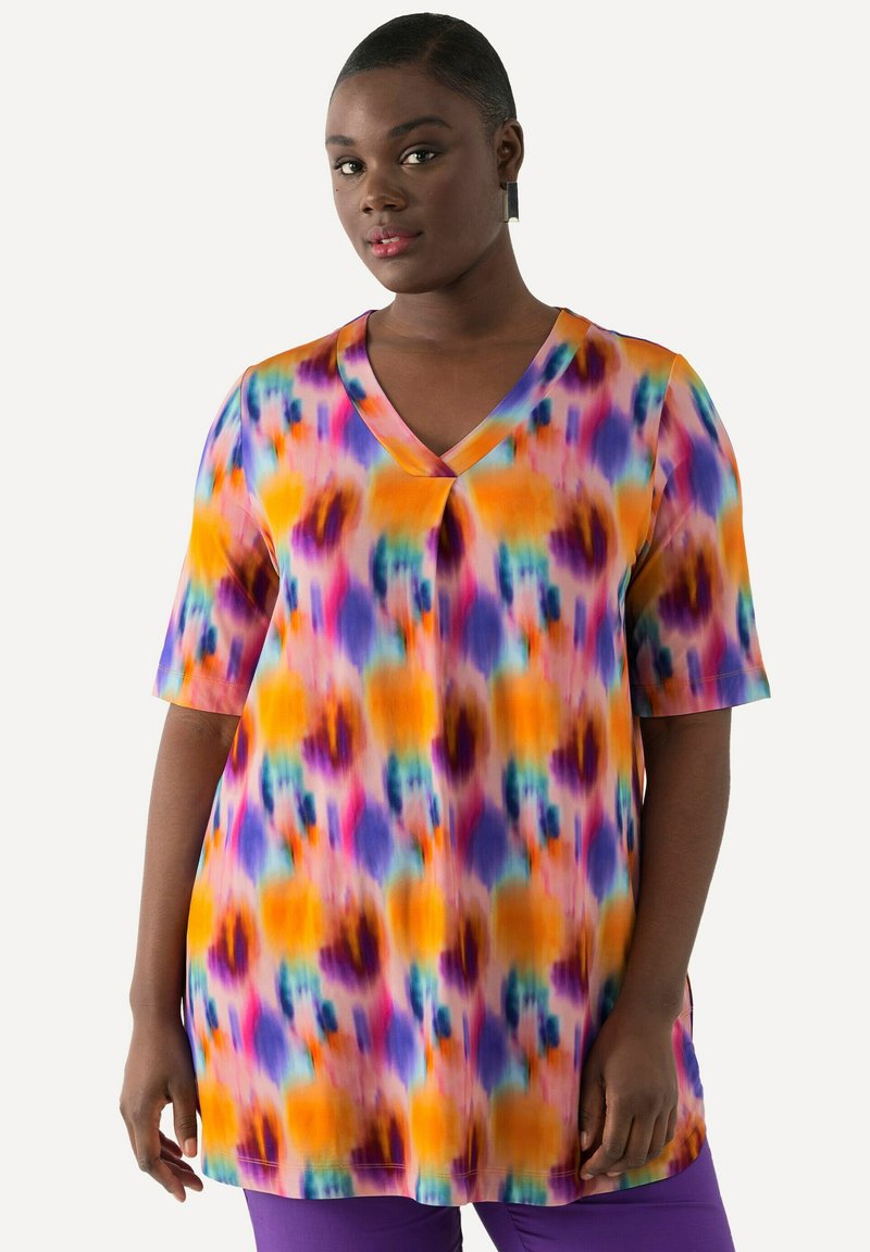 Túnica de cuello en V con un patrón de tie-dye multicolor en tonos naranjas, morados y azules, con mangas cortas y un corte relajado.