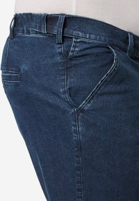 Džínové kalhoty v tmavě modré barvě s mírným vyblednutím, se rovný střih, přední a zadní kapsy a přiléhavý pas s poutky na opasek.