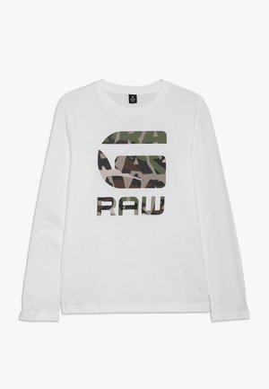 Chemise blanche à manches longues avec un col rond et un grand logo à motif camouflage ainsi que le mot "RAW" sur le devant.