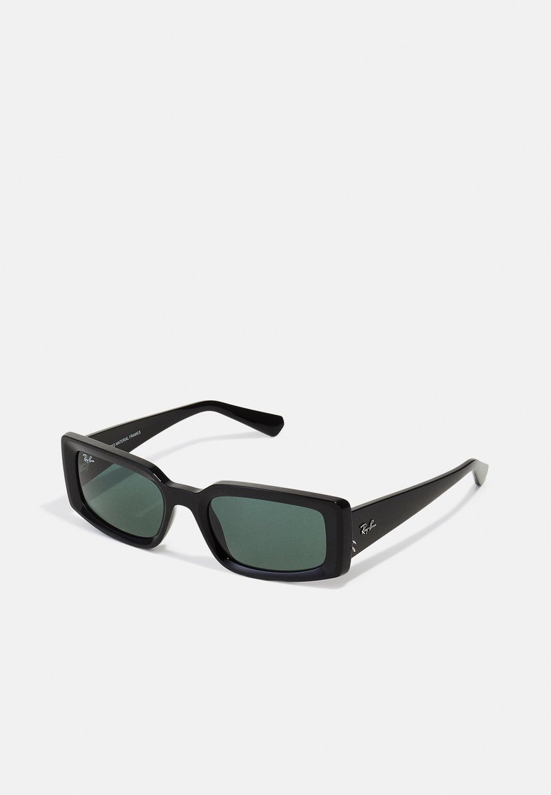 Ochelari de soare negri, dreptunghiulari, cu lentile verzi. Fabricați din plastic, cu rame groase și brațe subțiri. Logo-ul Ray-Ban pe un braț.