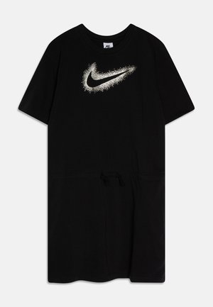 Robe Nike noire à manches courtes avec un logo swoosh blanc tacheté sur la poitrine et une taille à cordon, posée à plat sur fond blanc.
