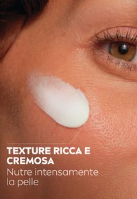 Crema idratante bianca e cremosa applicata sulla pelle, che mette in risalto una texture liscia su toni di pelle marroni e i minimi dettagli della superficie cutanea.