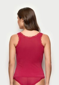 Rød tanktop med blonder detaljer på stropperne, tætsiddende design, lavet af blødt materiale. Bagsiden viser en glat tekstur og en pæn nederkant.