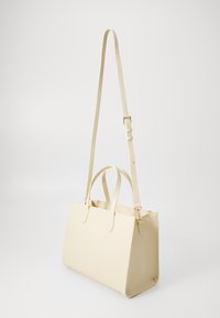 Beige leather handbag with two top handles and an adjustable shoulder strap. Rectangular shape, smooth texture, minimalistic design.