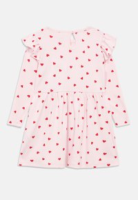 Φόρεμα ροζ με μακριά μανίκια και φουσκωτή φούστα, με κόκκινο σχέδιο καρδιάς και βολάν στα μανίκια. Κούμπωμα στο πίσω μέρος με λεπτομέρεια κλειδαρότρυπας.