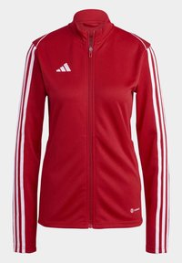Red zip-up jacket with high collar, white three-striped accents on sleeves, smooth texture, and small logo detail on the chest.