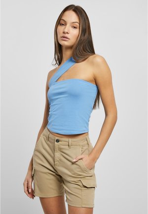 Top sin mangas de color azul claro con un diseño asimétrico y una tirante ancho. Combinado con pantalones cortos de carga beige, hasta la rodilla, que cuentan con bolsillos.