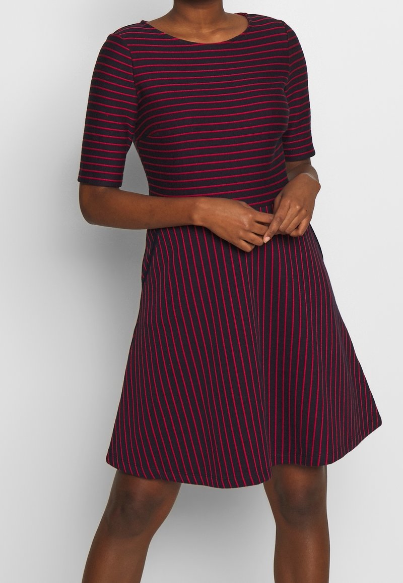 Navykleid mit kurzen Ärmeln, mit rosa horizontalen Streifen. A-Linien-Form, runder Ausschnitt, weicher Baumwollstoff und knielanger Saum.