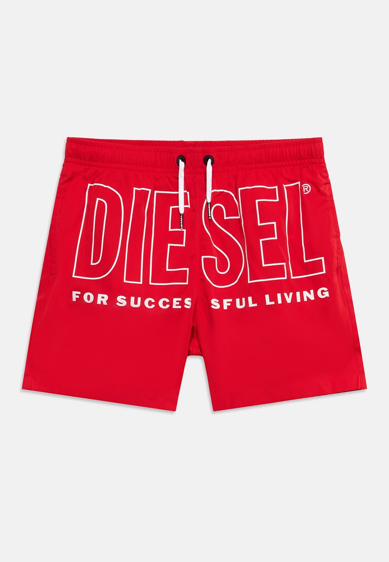Κόκκινα μαγιό σορτς με λευκά κορδόνια και μεγάλο λευκό γράμμα "DIESEL" στο μπροστινό μέρος, με μερική εμφάνιση του κειμένου "FOR SUCCESSFUL LIVING."