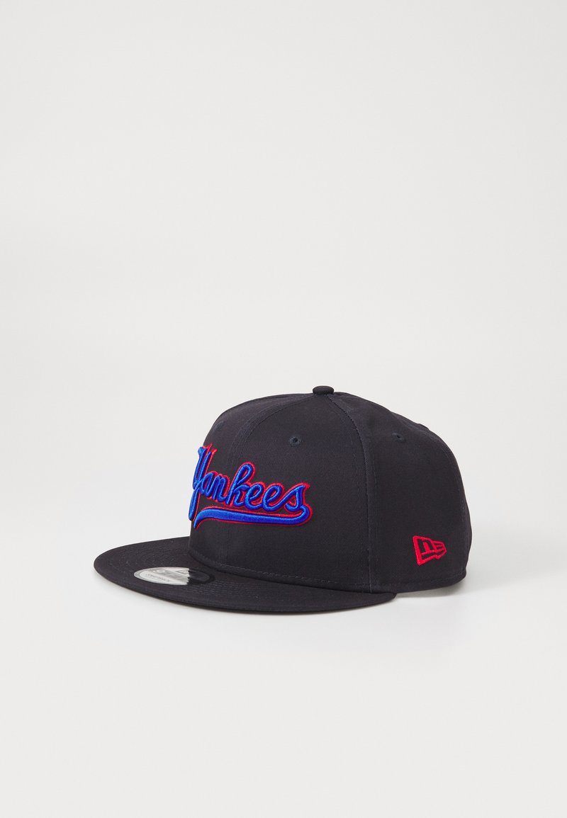 Gorra de béisbol negra con el logo bordado de "Yankees" en azul y rojo. Visera plana, corona estructurada, logo de New Era en rojo en el lateral.